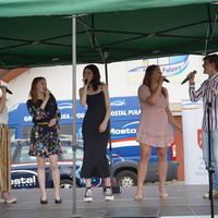 Na zdjęciu piątka młodych ludzi śpiewajaca na scenie
