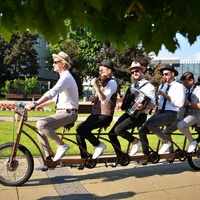 Zdjęcie muzyków na wieloosobowym rowerze