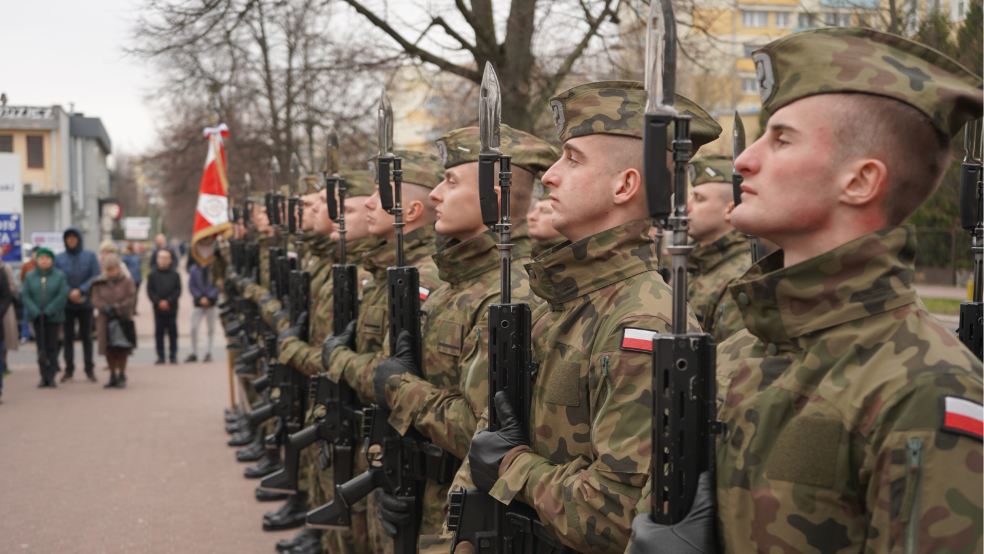 Żołnierze z karabinami podczas uroczystości patriotycznej